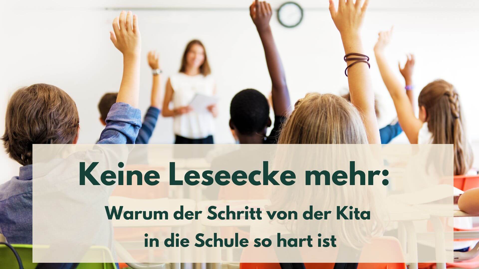 Kinder in einer Schuklasse, die ihre Hand heben, im Hintergrund eine Lehrerin